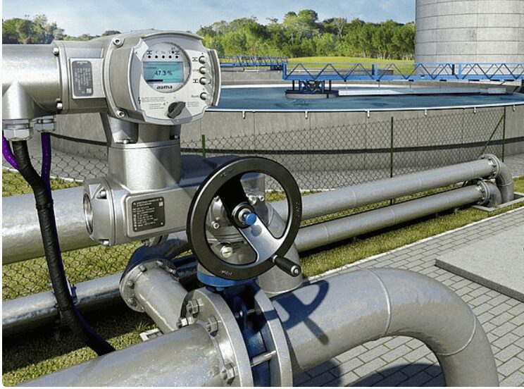 A close-up of industrial pipes and a valve wheel outdoors. A close-up of industrial pipes and a valve wheel outdoors.